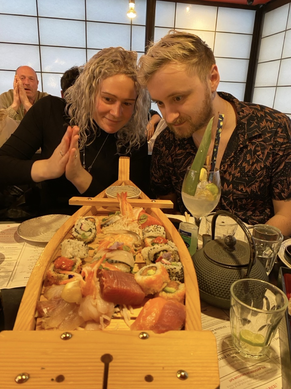 Sophie and Joe looking at a massive boat of sushi.