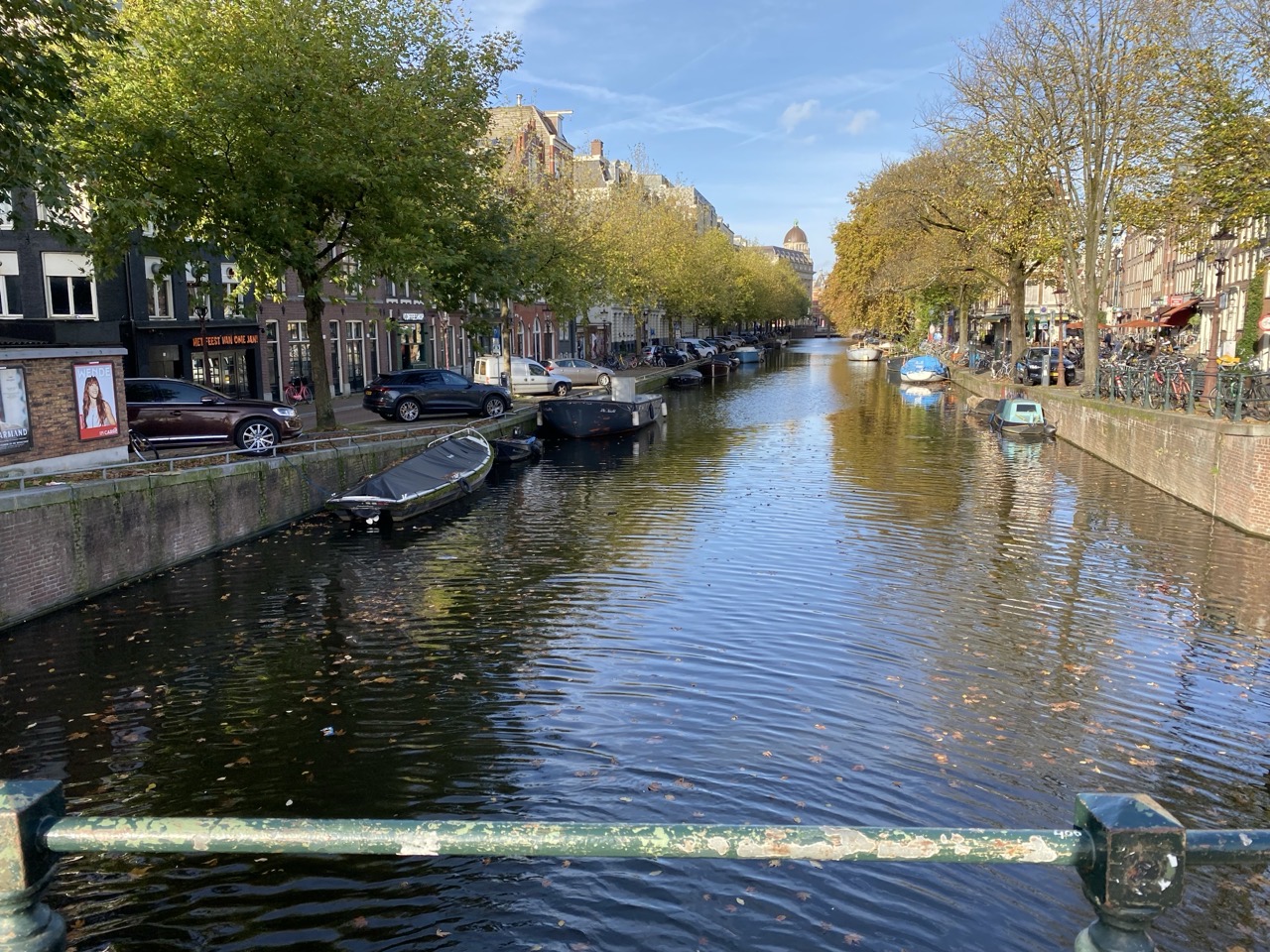 A canal with a blue sky and autumn trees