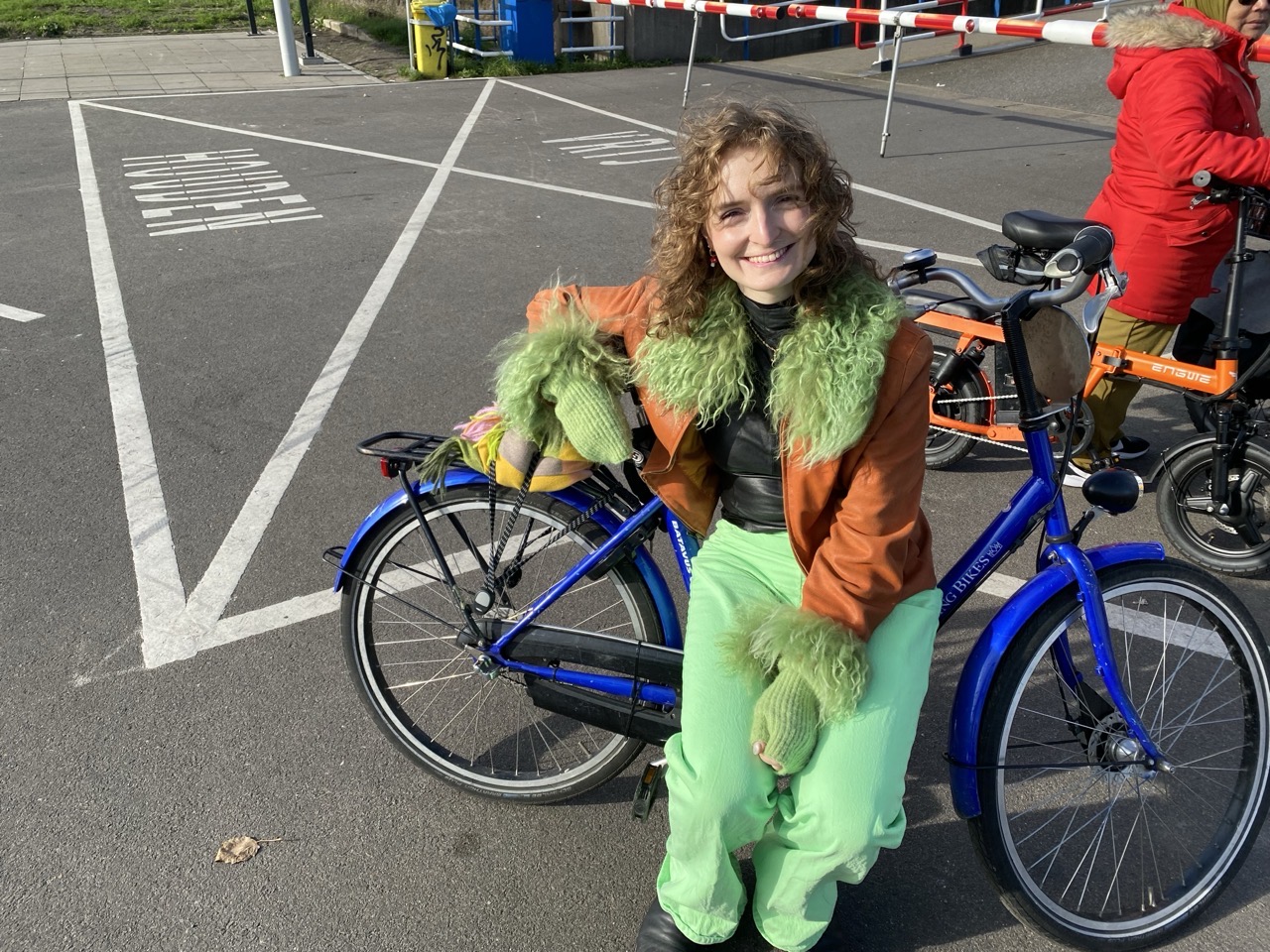 Lucy sitting on a blue bicycle