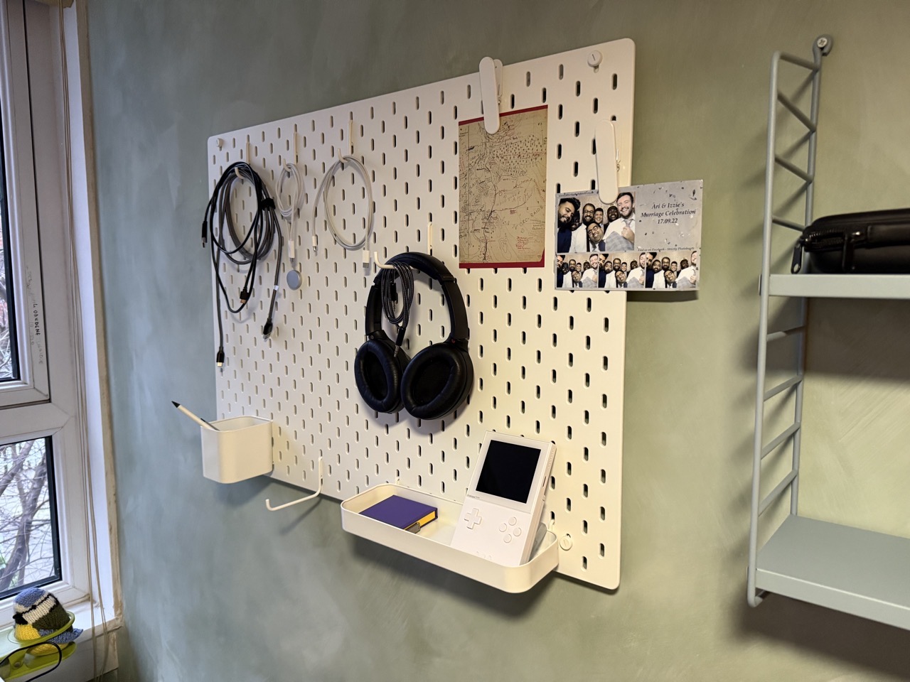 It’s an Ikea pegboard thing on a wall. There are cables and headphones and an Analogue Pocket.