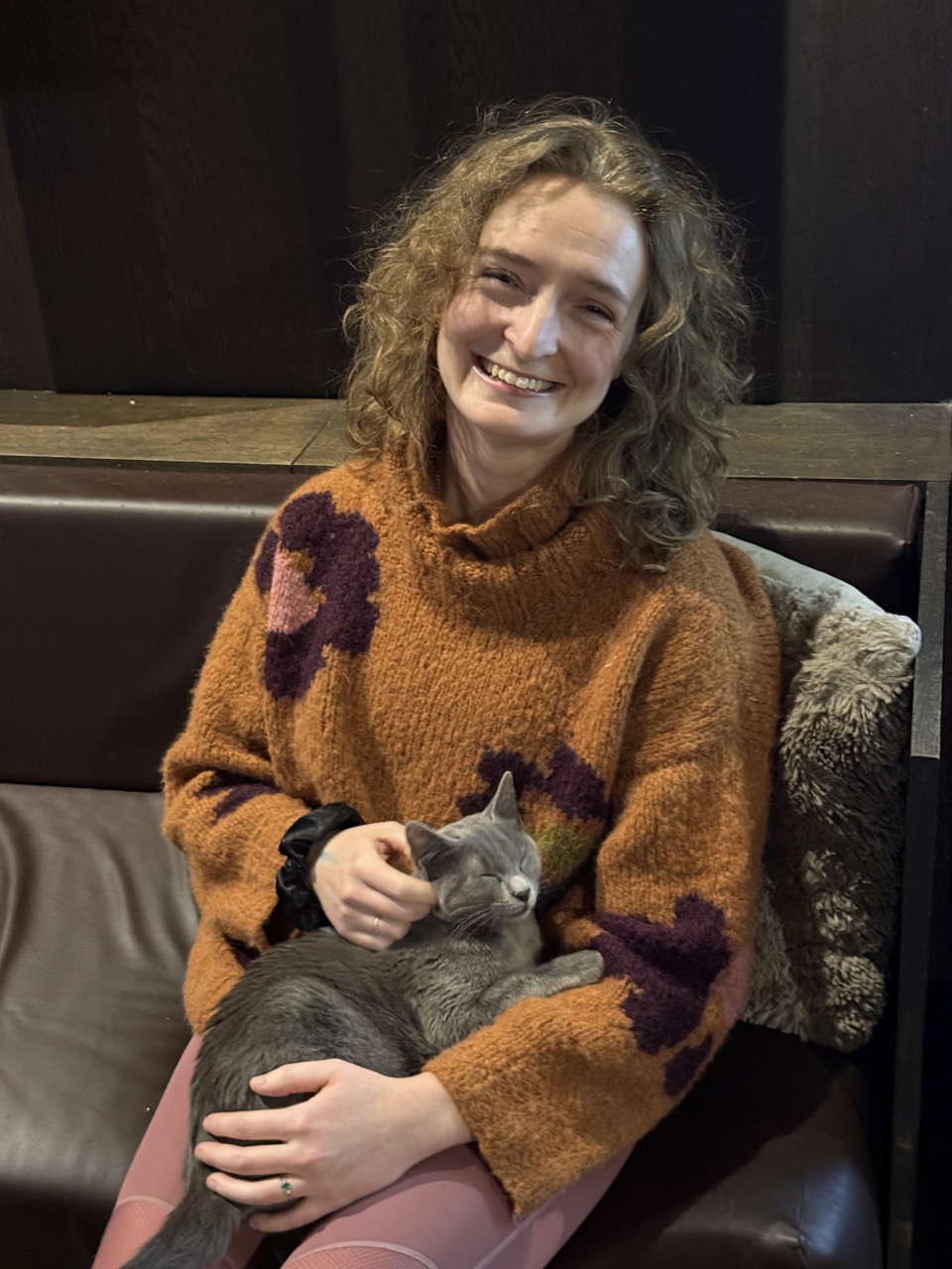 Lucy holding a little grey cat and looking appropriately delighted