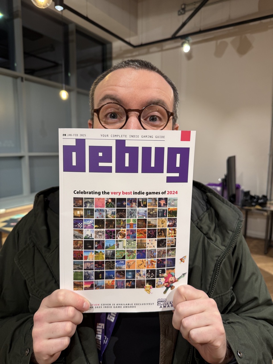 Me holding Debug magazine with lots of games on it including Feud